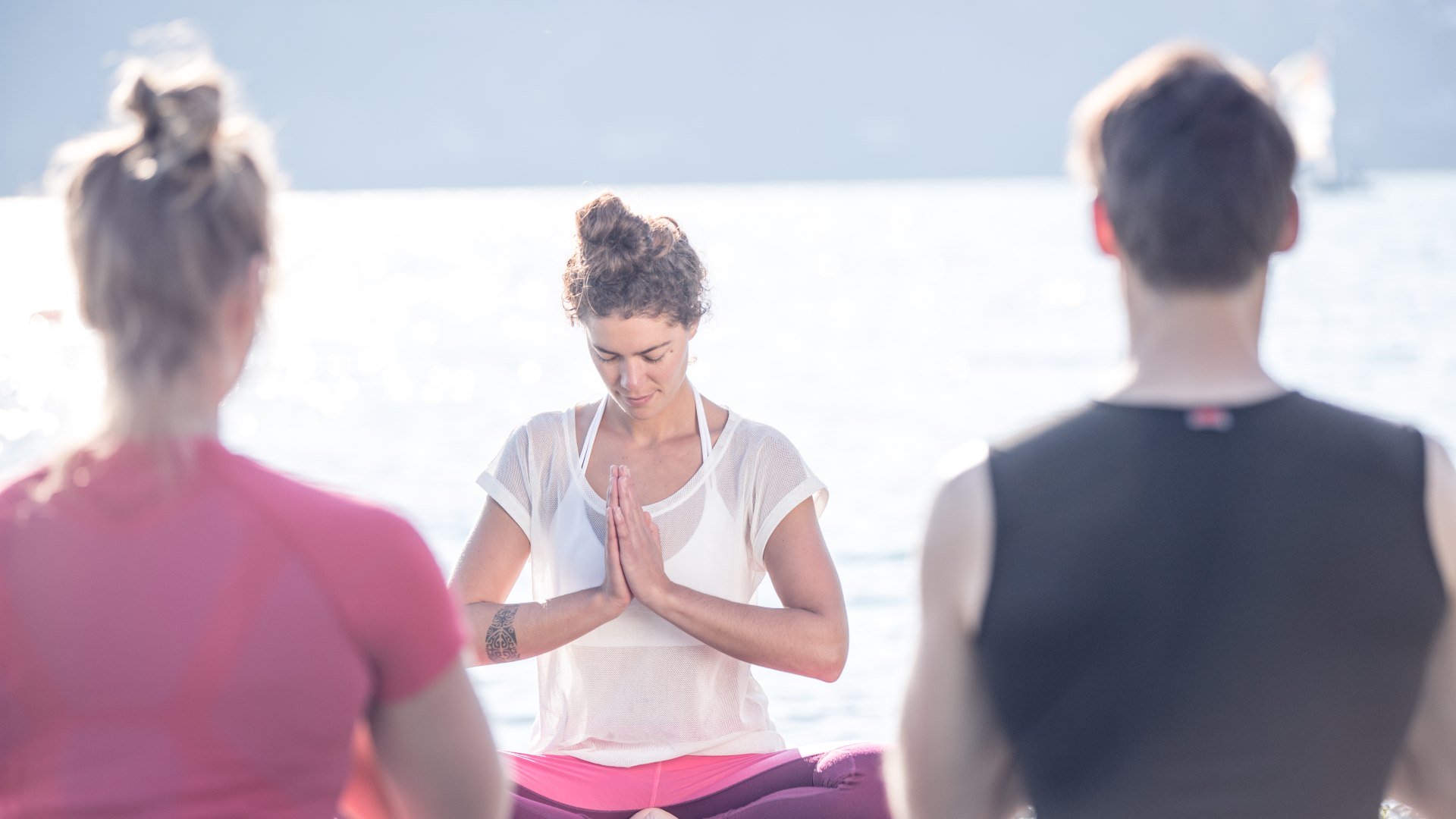 Mit dem Abschiedsgruß Namaste beendet die Yogalehrerin ihre Yogastunde unter dem blauen Himmel am Ufer des Tegernsees in Bad Wiessee., © Hansi Heckmair