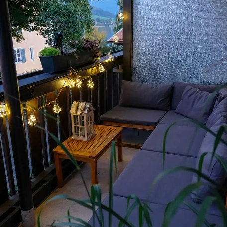 Abendstimmung in der Lounge-Ecke auf dem Balkon mit seitlichem Blick auf den See, &copy; Ferienwohnung Auszeit am See