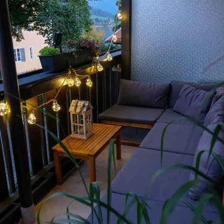 Abendstimmung in der Lounge-Ecke auf dem Balkon mit seitlichem Blick auf den See, &copy; Ferienwohnung Auszeit am See
