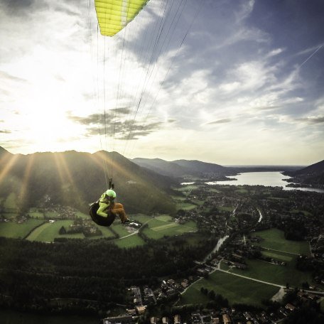 Paraglider fliegt dem Tegernsee und der Sonne entgegen, © Dietmar Denger