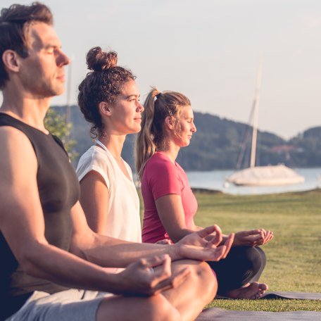 Yogaklasse genießt am Ufer von Bad Weissee am Tegernsee die ersten Sonnenstrahlen, © Hansi Heckmair