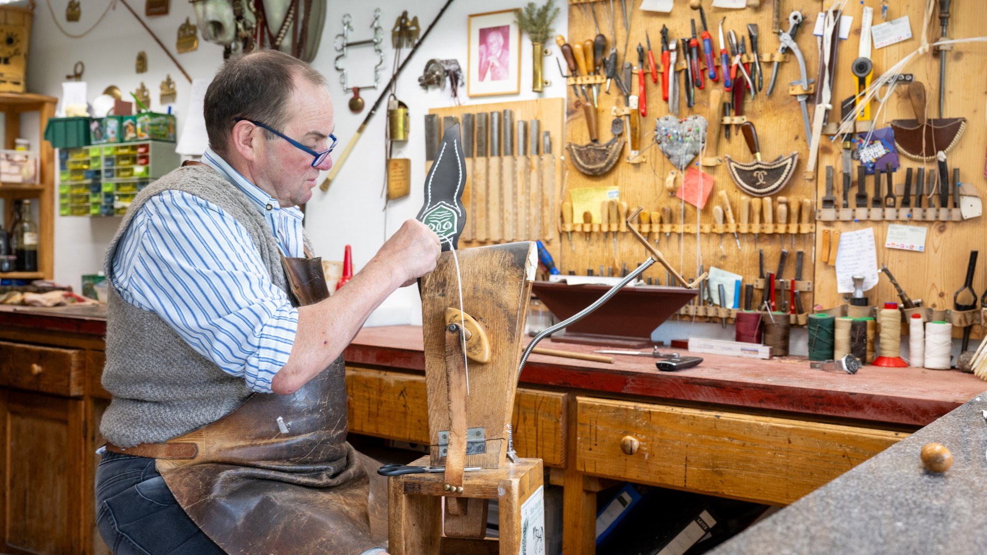 In seiner Werkstatt sitzt Federkielsticker Karl Stecher auf dem sogenannten R&ouml;ssl