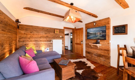 gemütliches Wohnzimmer mit Einbauten aus echtem Altholz und Smart-TV, © im-web.de/ Tourist-Information Bad Wiessee