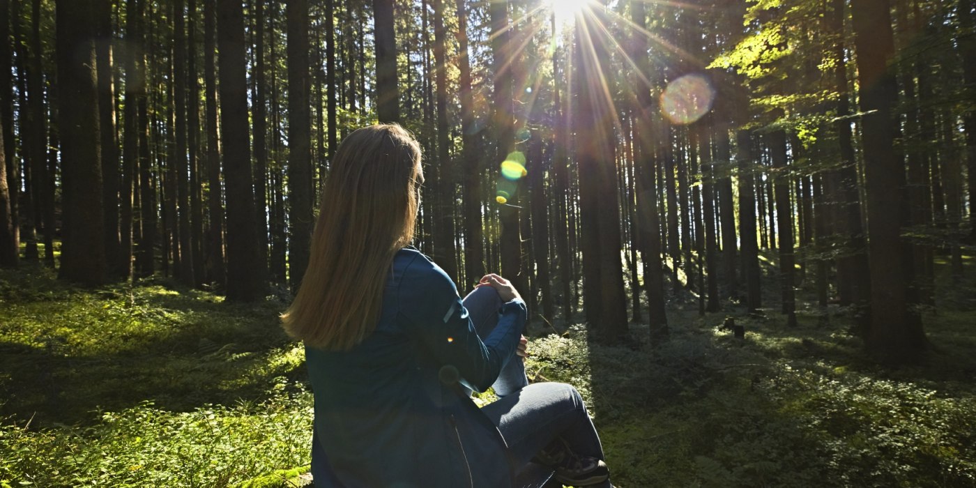 Eine Frau genießt die Sonnenstrahlen auf einer Waldlichtung., © www.bayern.by - Gert Krautbauer