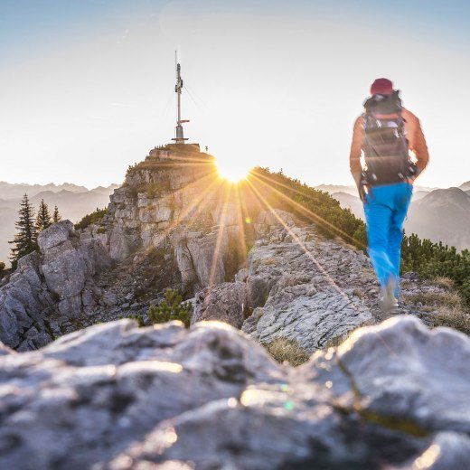 Wanderer bei Sonnenaufgang kurz vor dem Gipfelkreuz Wallberg, © Dietmar Denger