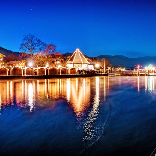 Die glitzernden Lichter der Weihnachtsmärkte spiegeln sich zur Weihnachtszeit im Tegernsee in den Bayrischen Voralpen., © Stefan Schiefer