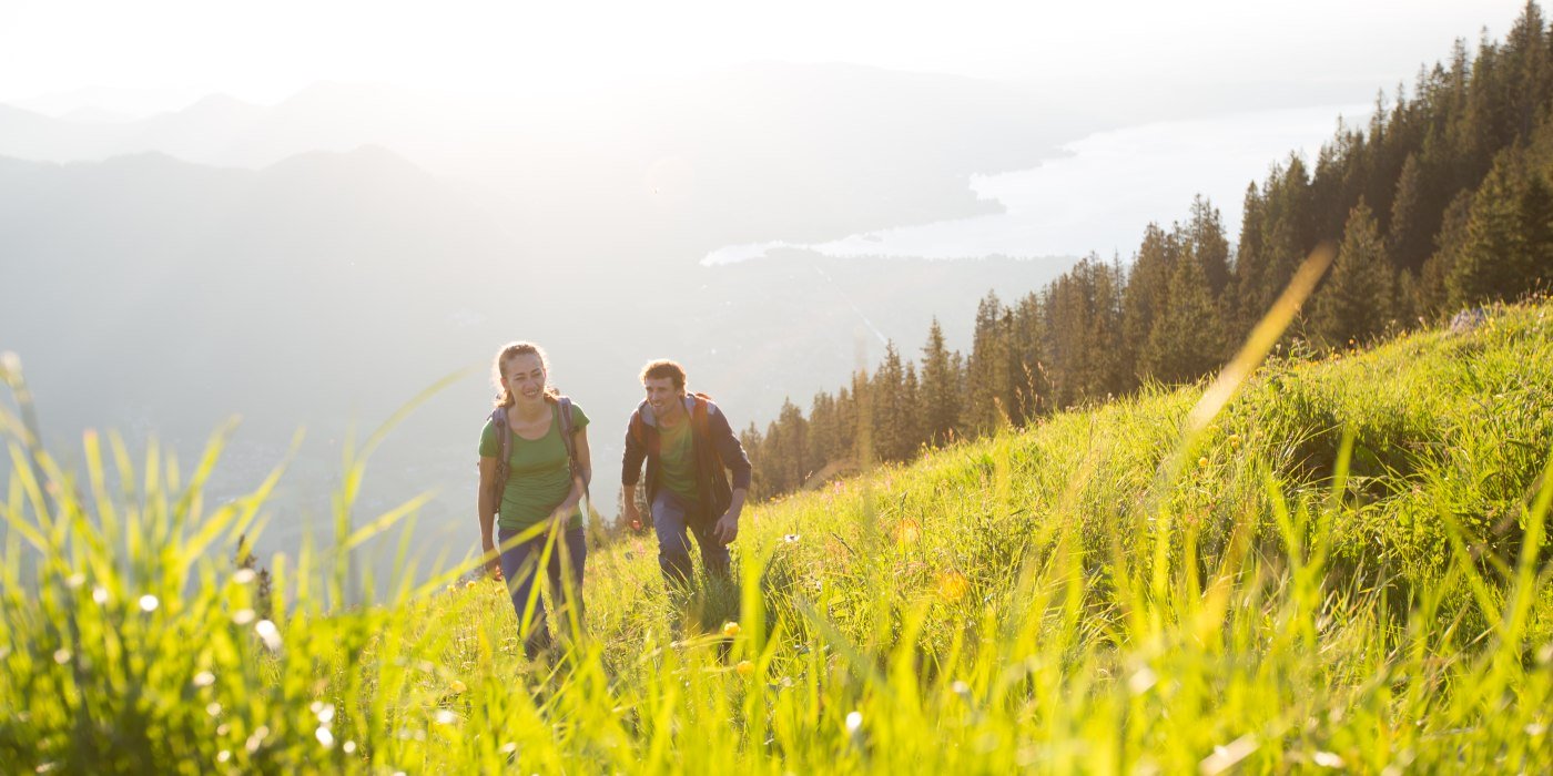 Paar wandert auf Wiese über dem Tegernsee, © Hansi Heckmair