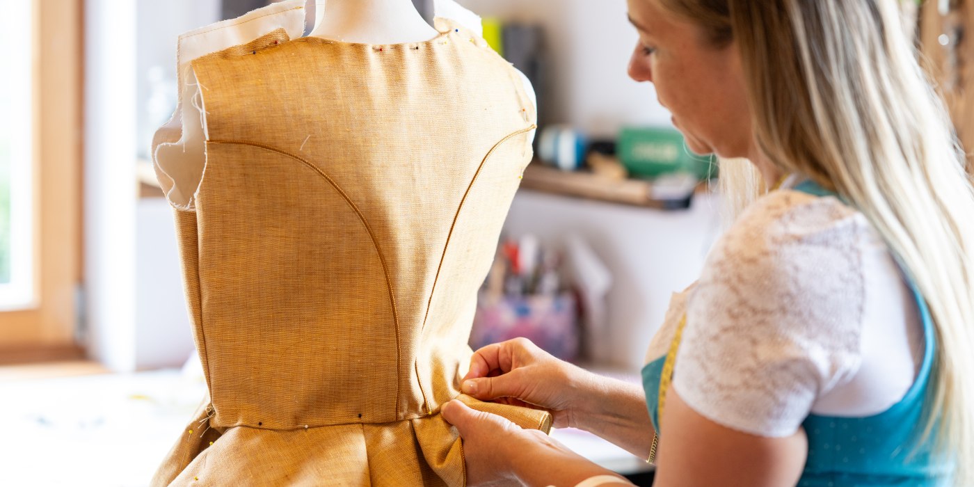Dirndlschneiderin Nicole Mahler steckt von Hand die typischen Falten beim Spenzer Dirndlschneiderin Nicole Mahler steckt von Hand die typischen Falten beim Spenzer