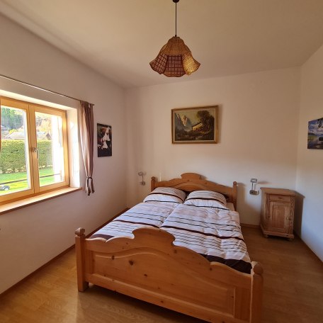Großes Schlafzimmer mit Doppelbett, Kleiderschrank und Waschbecken Blick in den hinteren Garten, © im-web.de/ Tourist-Information Bad Wiessee