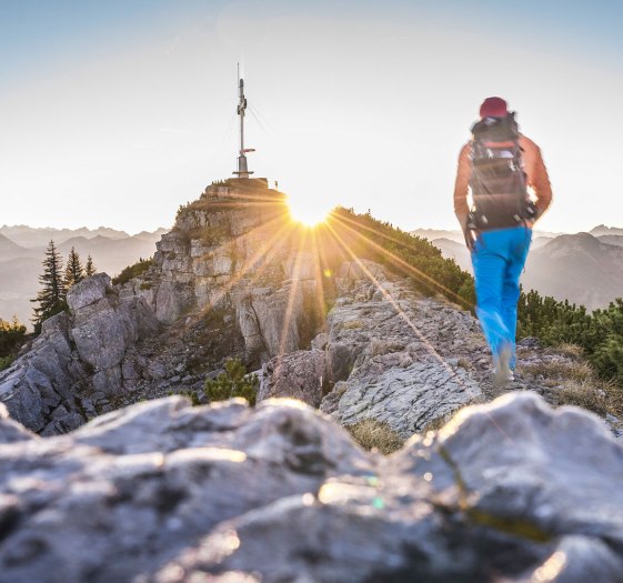 Wanderer bei Sonnenaufgang kurz vor dem Gipfelkreuz Wallberg, © Dietmar Denger