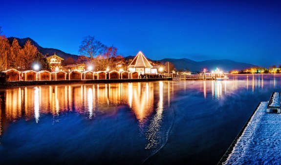 Die glitzernden Lichter der Weihnachtsmärkte spiegeln sich zur Weihnachtszeit im Tegernsee in den Bayrischen Voralpen., © Stefan Schiefer