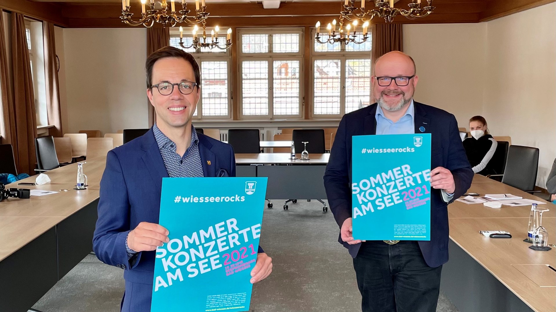 Der Wiesseer Bürgermeister Robert Kühn (l.) präsentiert mit TTT-Geschäftsführer Christian Kausch das neue Plakat #wiesseerocks .  , © Der Tegernsee