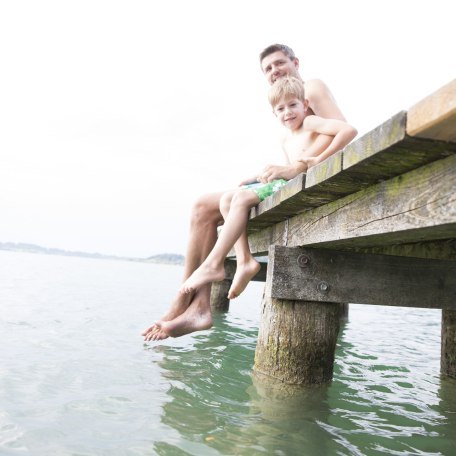Father and son on jetty at Tegernsee, © Hansi Heckmair
