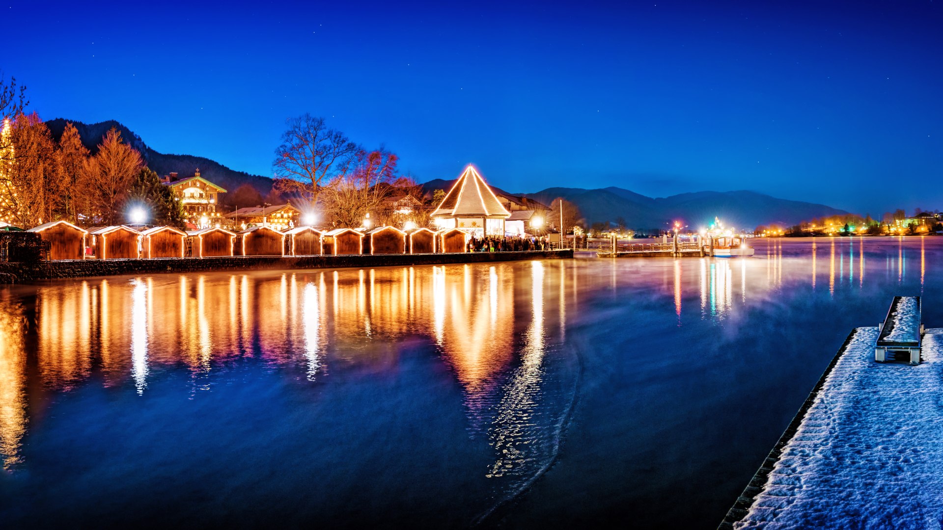 Die glitzernden Lichter der Weihnachtsmärkte spiegeln sich zur Weihnachtszeit im Tegernsee in den Bayrischen Voralpen., © Stefan Schiefer